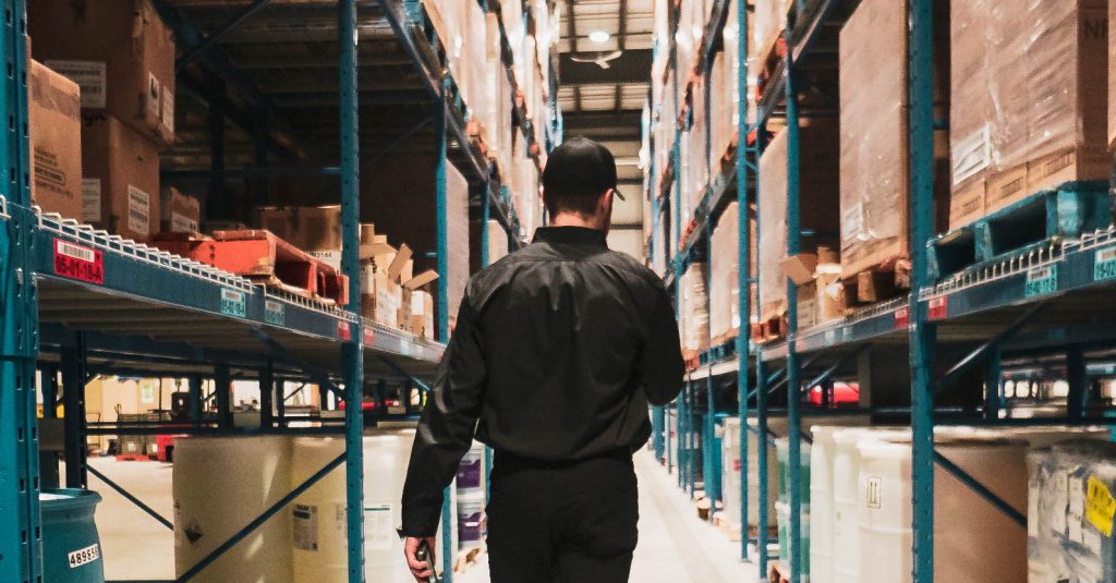 Image of a Newterm Employee walking down am isle of the warehouse